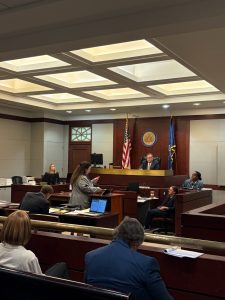 Attorney Rachelle Miller delivers oral argument at the podium during a mock trial exercise at the 2025 Primerus Trial Skills Academy, with a judge, witnesses, and participants observing in a simulated courtroom setting at Mercer Law School.
